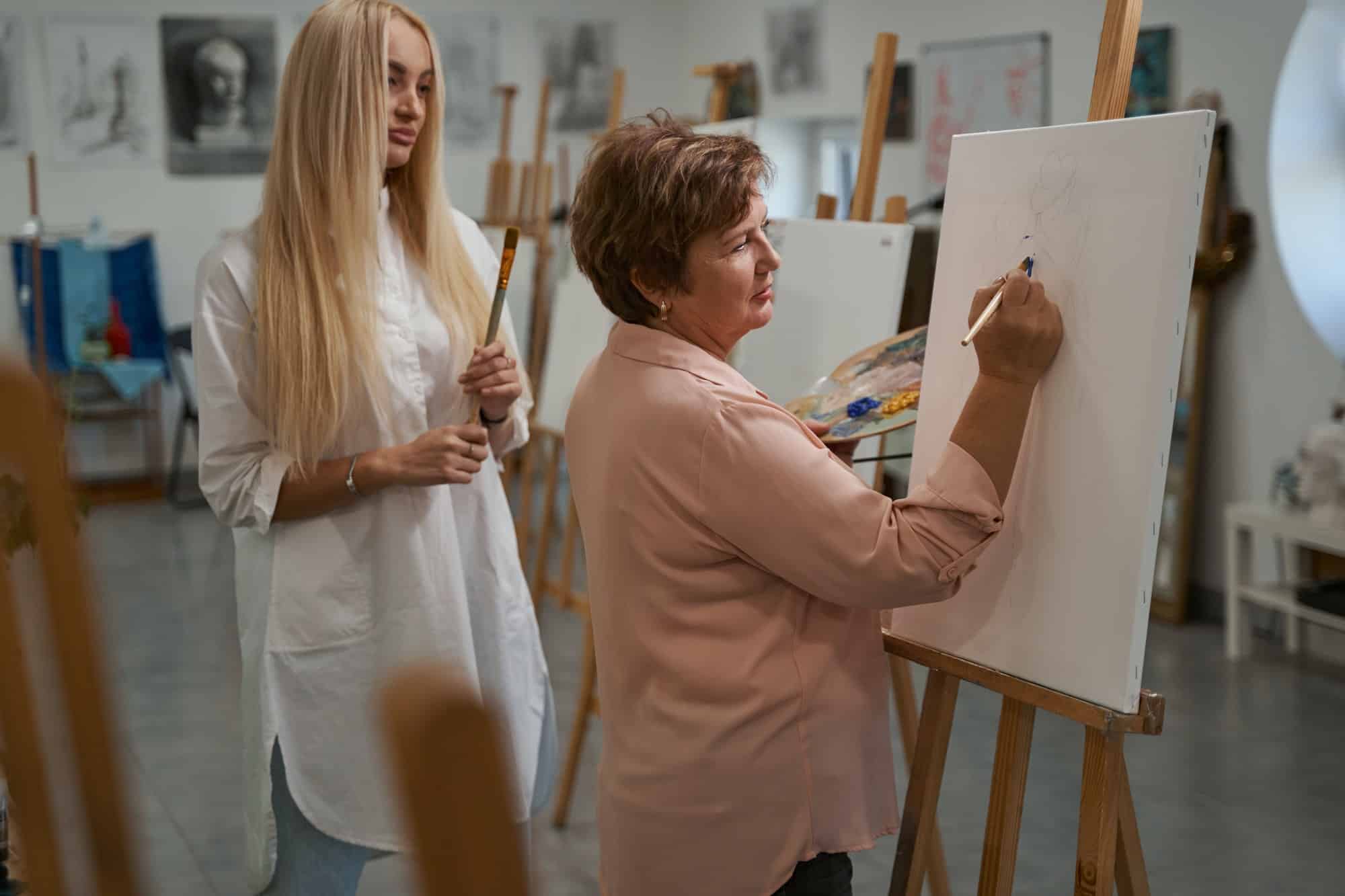 Delighted aged woman having art therapy in workshop